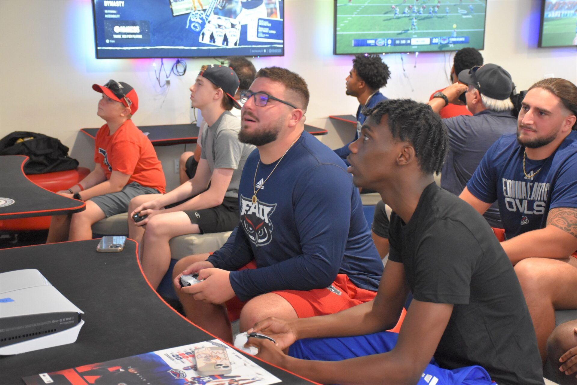 Florida Atlantic offensive lineman Andre Lamas plays EA Sports College Football 25 at the FAU launch party while teammate Federico Maranges watches on (July 17, 2024).