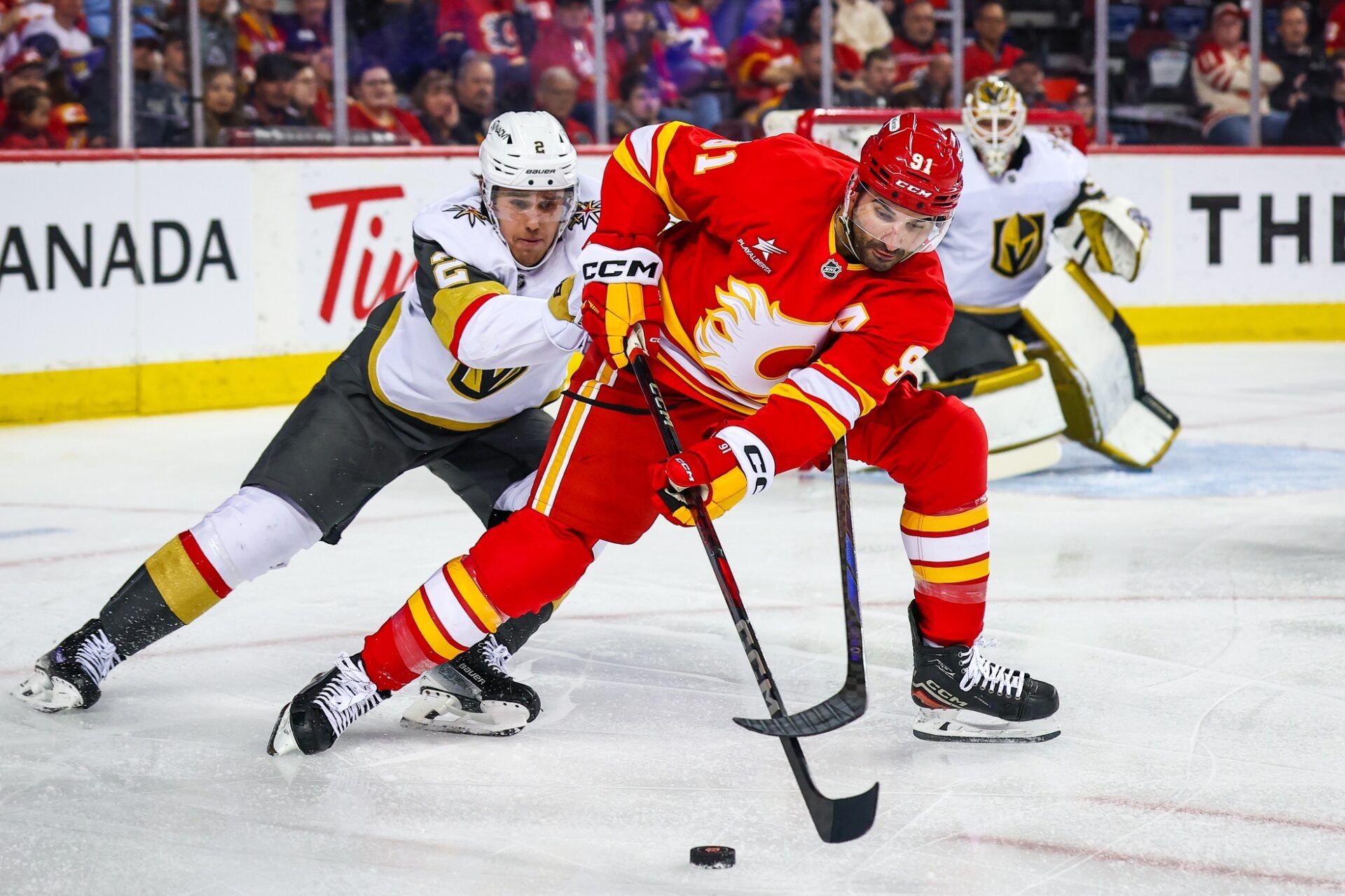 Calgary Flames center Nazem Kadri (91) and Vegas Golden Knights defenseman Zach Whitecloud (2) battles for the puck during the second period at Scotiabank Saddledome.