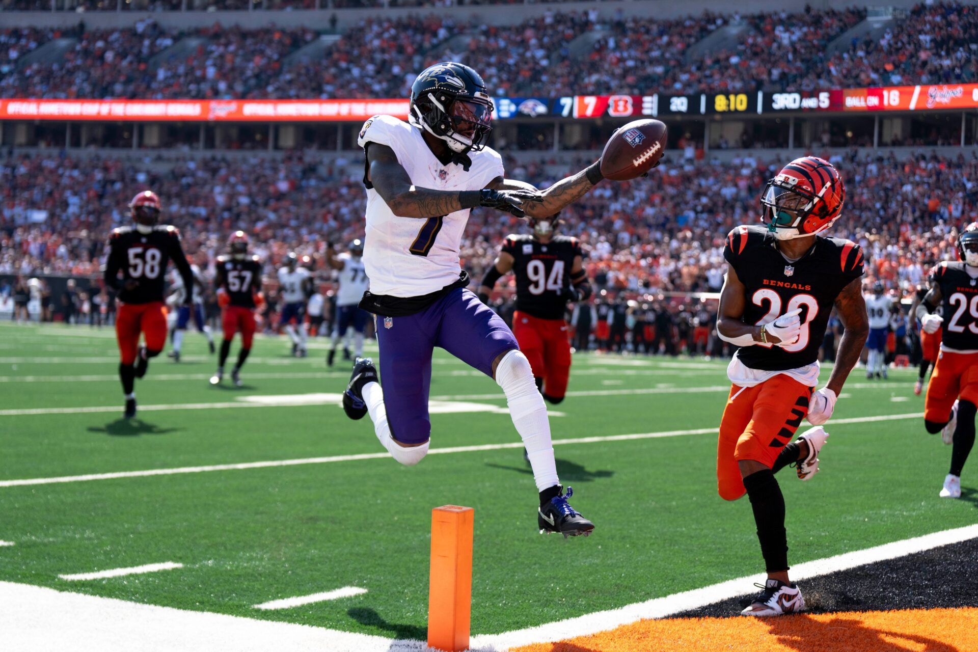 Baltimore Ravens wide receiver Rashod Bateman (7) scores a touchdown as Cincinnati Bengals cornerback Josh Newton (28) attempts to stop him in the first quarter of the NFL game at Paycor Stadium in Cincinnati on Sunday, Oct. 6, 2024.