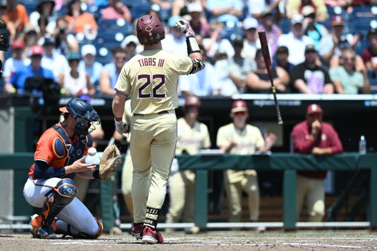 Florida State Seminoles right fielder James Tibbs III (22) flips the back after walking and driving in a run against the Virginia Cavaliers during the third inning at Charles Schwab Field Omaha.