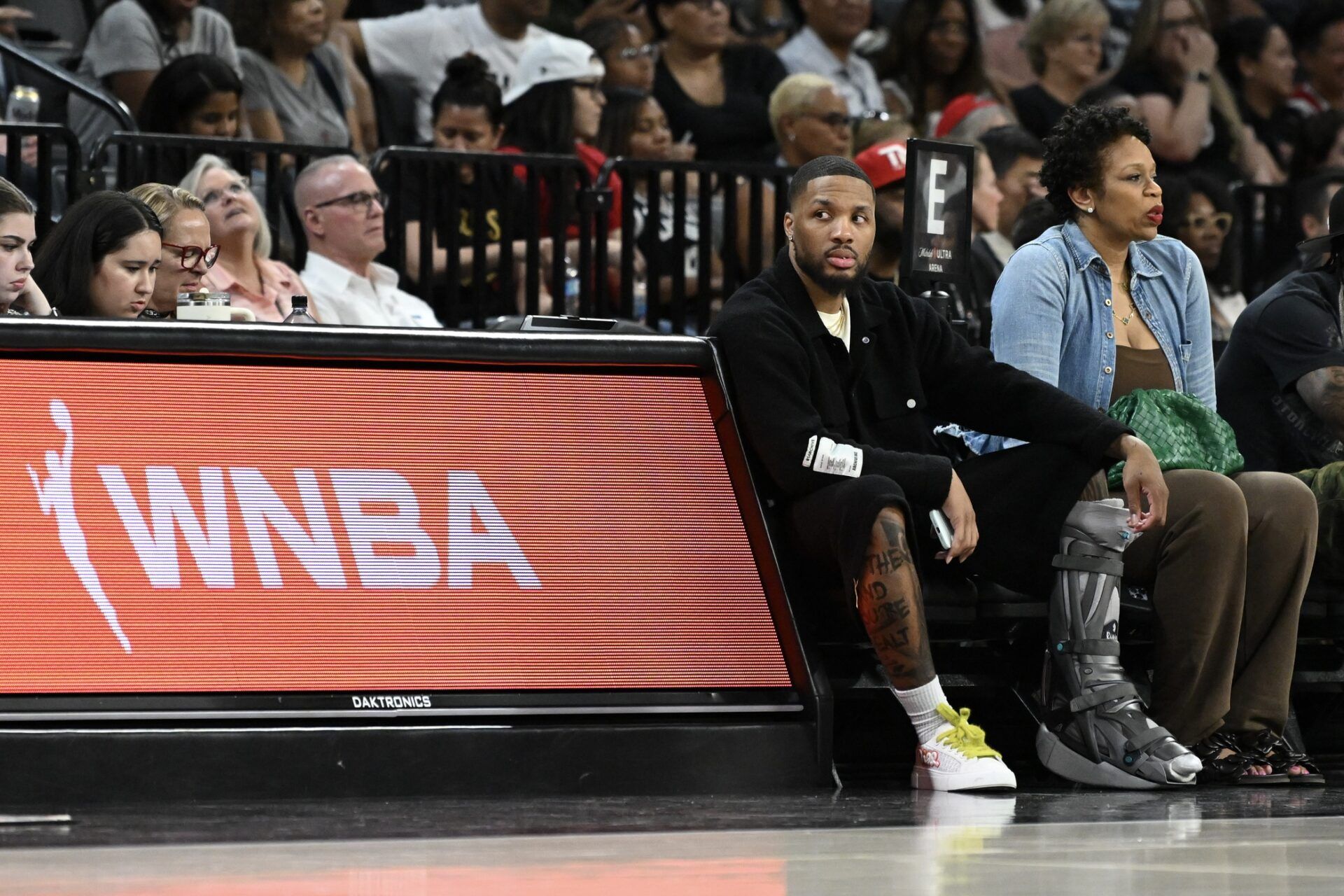 NBA player Damian Lillard sits courtside during the Las Vegas Aces and Los Angeles Sparks game at Michelob Ultra Arena.