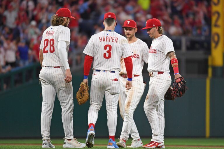 Philadelphia Phillies third base Alec Bohm (28), first base Bryce Harper (3), shortstop Trea Turner (7) and second base Bryson Stott (5) celebrate win against the San Diego Padres at Citizens Bank Park.