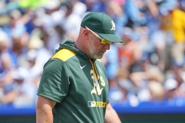 Athletics manager Mark Kotsay (7) returns to the dugout against the Kansas City Royals after making a pitching change in the seventh inning at Kauffman Stadium.