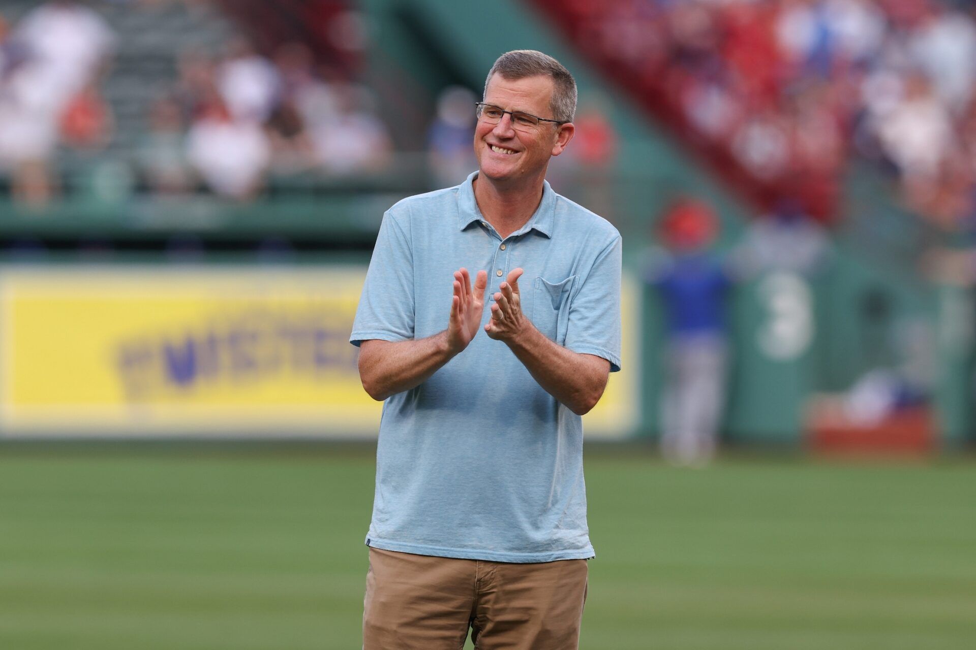 President and CEO of the Boston Red Sox Sam Kennedy applauds before a game against the Kansas City Royals at Fenway Park.