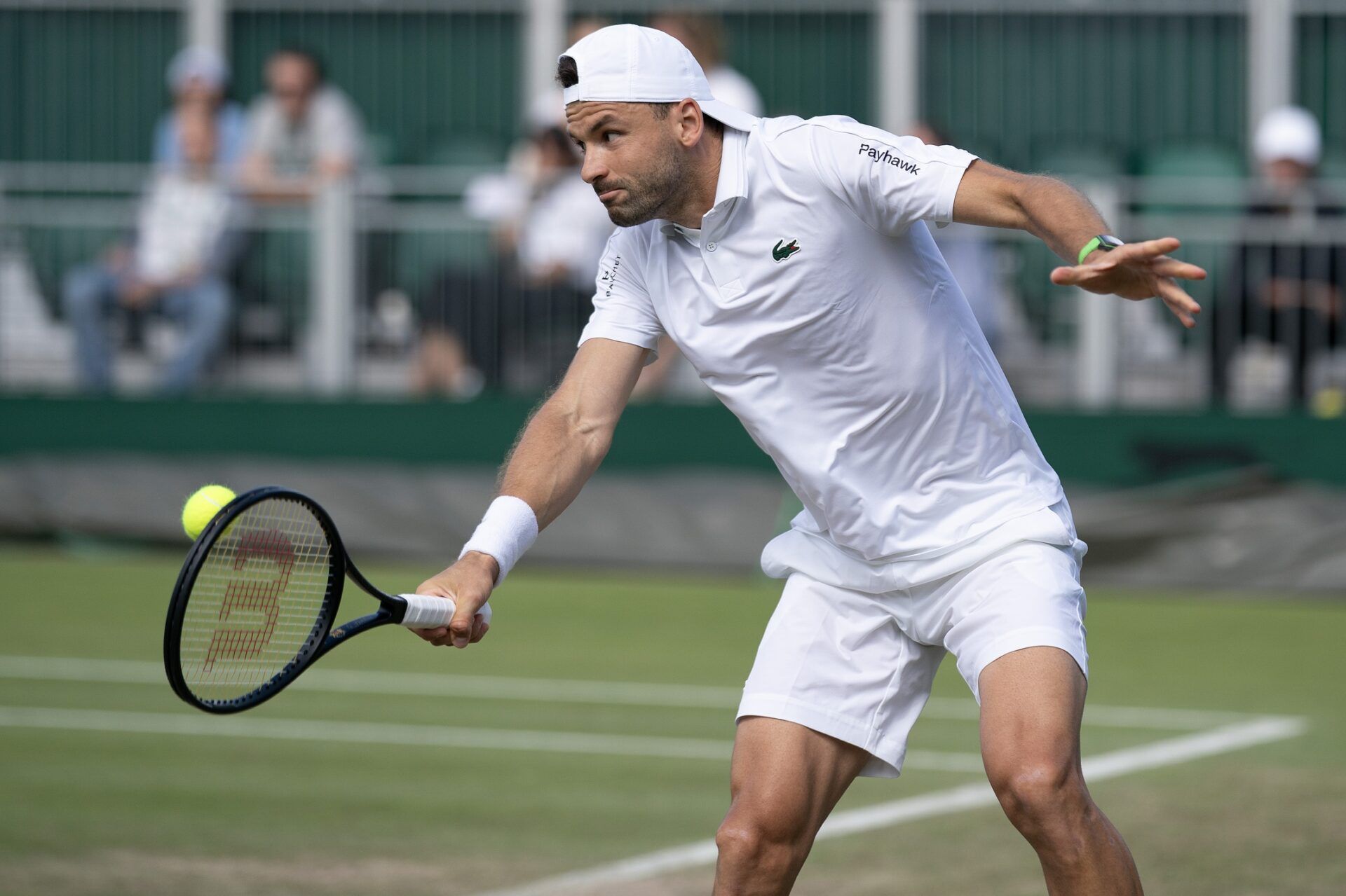 Grigor Dimitrov of Bulgaria returns a shot during his match against Juncheng Shang of China (not shown) on day four of The Championships at All England Lawn Tennis and Croquet Club.