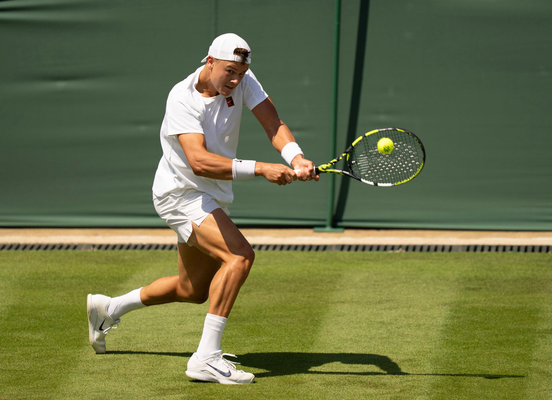 Holger Rune of Denmark returns a shot during his match against Nicolas Jarry of Chile on day one at the All England Lawn Tennis and Croquet Club.