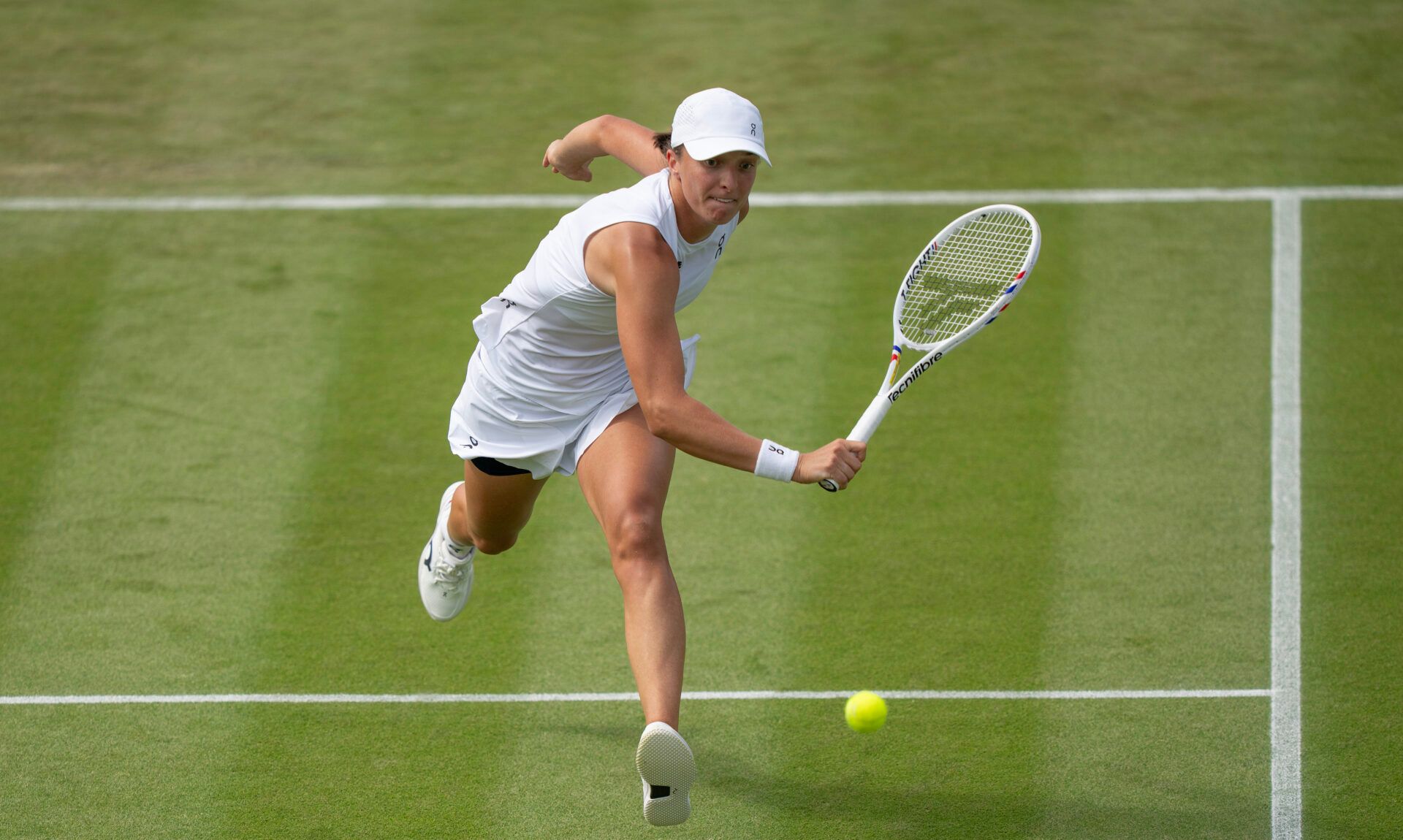 Iga Swiatek of Poland returns a shot during her match against Polina Kudermetova on day two at the All England Lawn Tennis and Croquet Club.