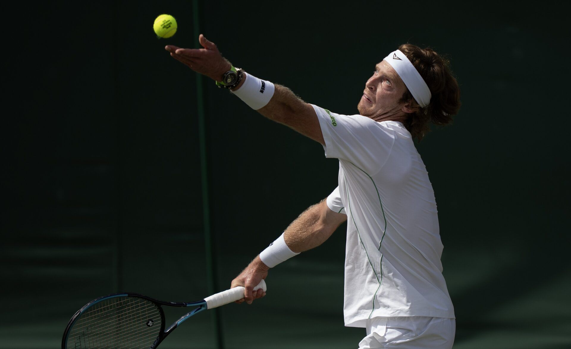 Andrey Rublev tosses the ball to serve during his match against Lloyd Harris of South Africa on day three at the All England Lawn Tennis and Croquet Club.