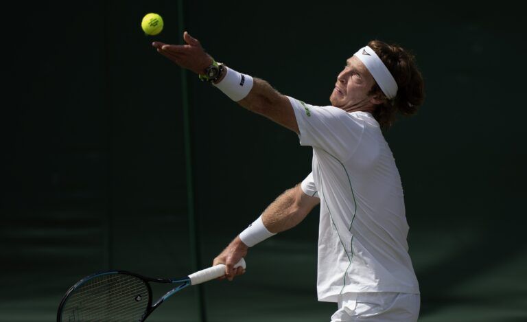 Andrey Rublev tosses the ball to serve during his match against Lloyd Harris of South Africa on day three at the All England Lawn Tennis and Croquet Club.