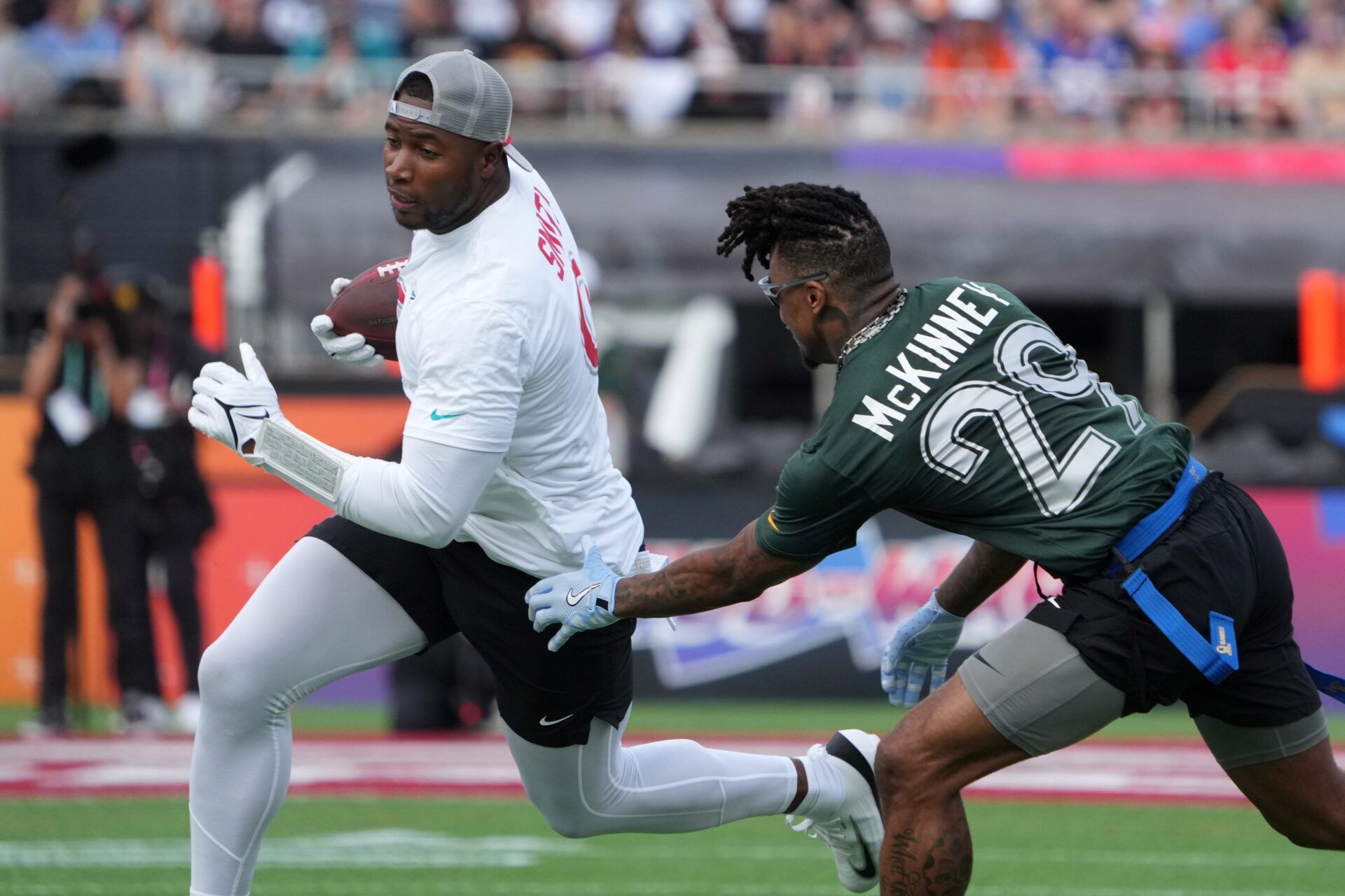 AFC tight end Jonnu Smith of the Miami Dolphins (9) carries the ball against NFC free safety Xavier McKinney of the Green Bay Packers (29) during the 2025 Pro Bowl Games at Camping World Stadium.