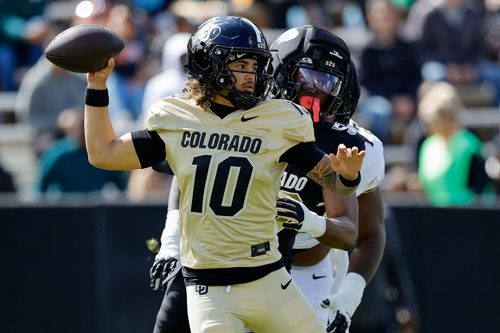 Colorado Buffaloes quarterback Julian Lewis (10) and defensive end Arden Walker (53) during the spring game at Folsom Field.