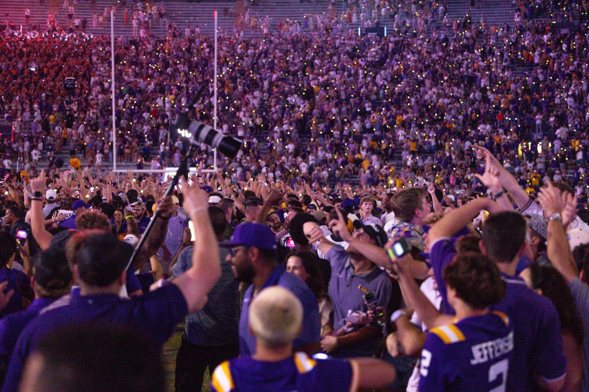 LSU Tigers fans storm the field after an overtime victory against the Mississippi Rebels at Tiger Stadium.