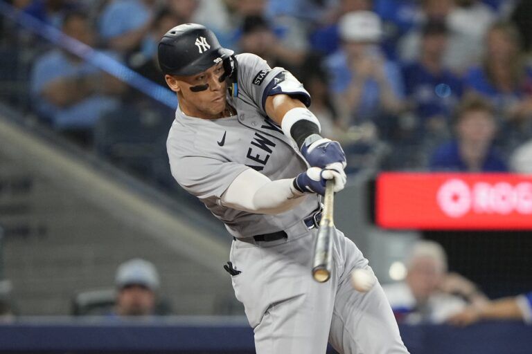 New York Yankees designated hitter Aaron Judge (99) hits a single against the Toronto Blue Jays during the seventh inning at Rogers Centre.