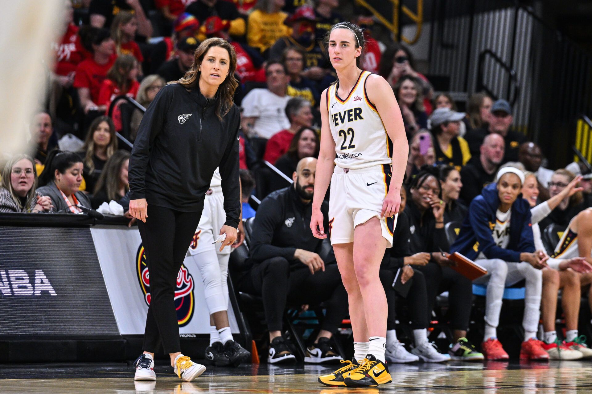 Indiana Fever guard Caitlin Clark (22) looks on with head coach Stephanie White during the third quarter against the Brazil National Team at Carver-Haweye Arena.