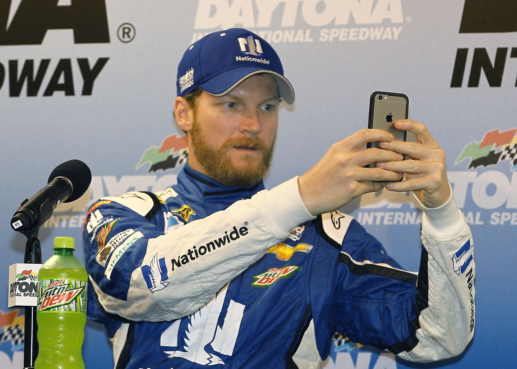 NASCAR Sprint Cup Series driver Dale Earnhardt Jr. (88) takes a panoramic photo for social media as speaks to the media during a conference for being a warded the pole after rain cancelled qualifications for the Coke Zero 400 at Daytona International Speedway.