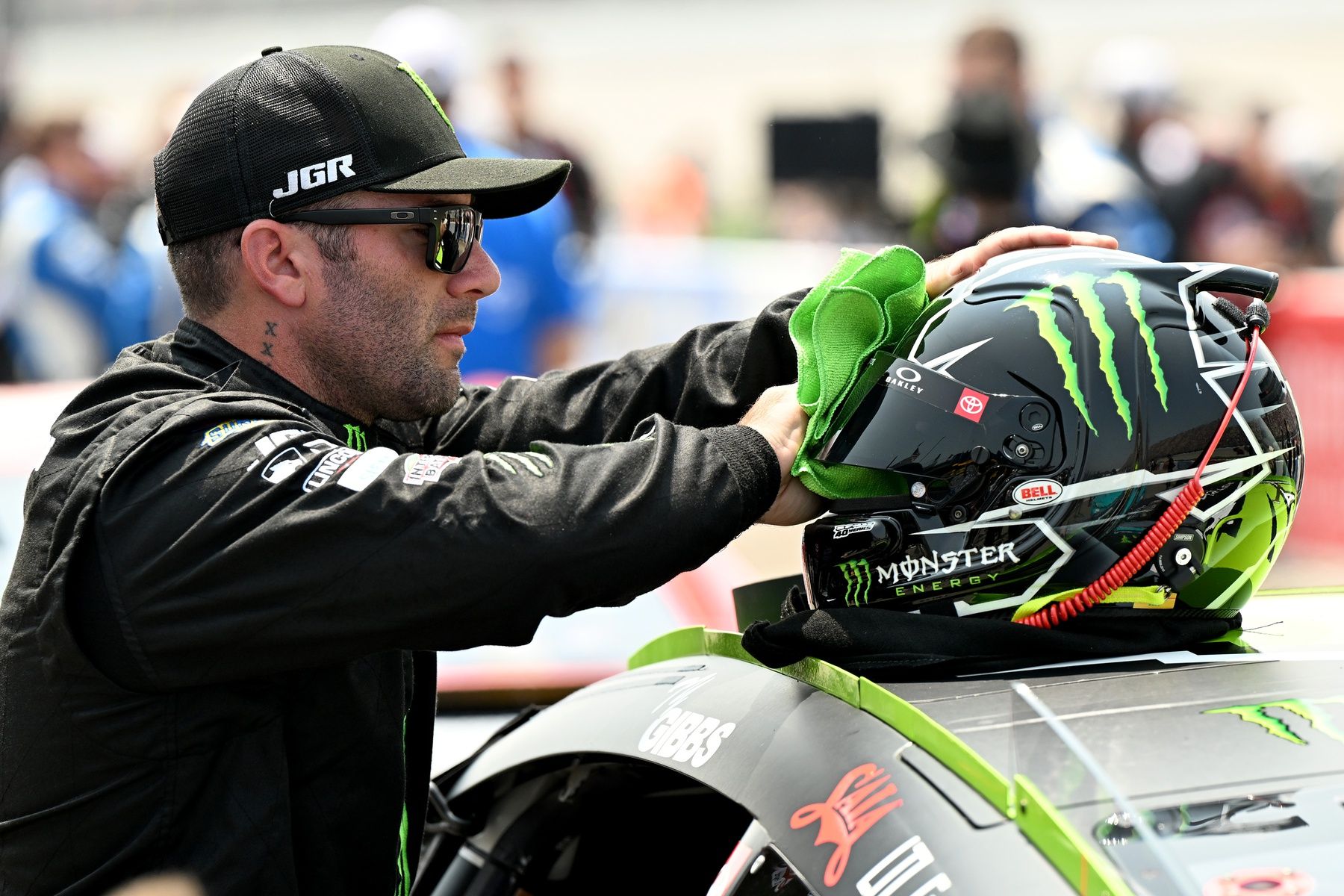 A crew member for NASCAR Cup Series driver Tyler Reddick (45) cleans the visor on his helmet before the start of the FireKeepers Casino 400 at Michigan International Speedway.
