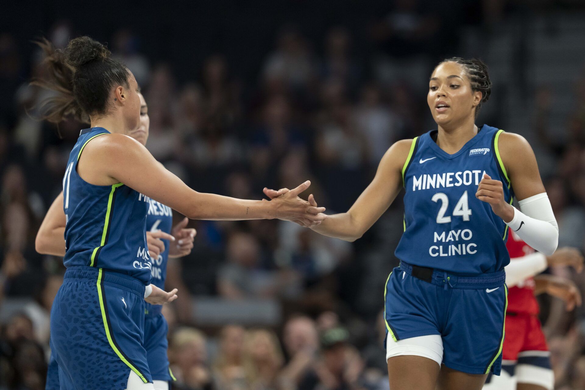 Minnesota Lynx forward Napheesa Collier (24) shakes hands with Minnesota Lynx guard Kayla McBride (21) after making a shot against the Washington Mystics in the first half at Target Center.
