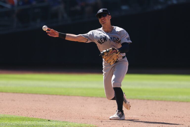 New York Yankees shortstop Anthony Volpe (11) throws the ball to first base for an out during the eighth inning against the New York Mets at Citi Field.