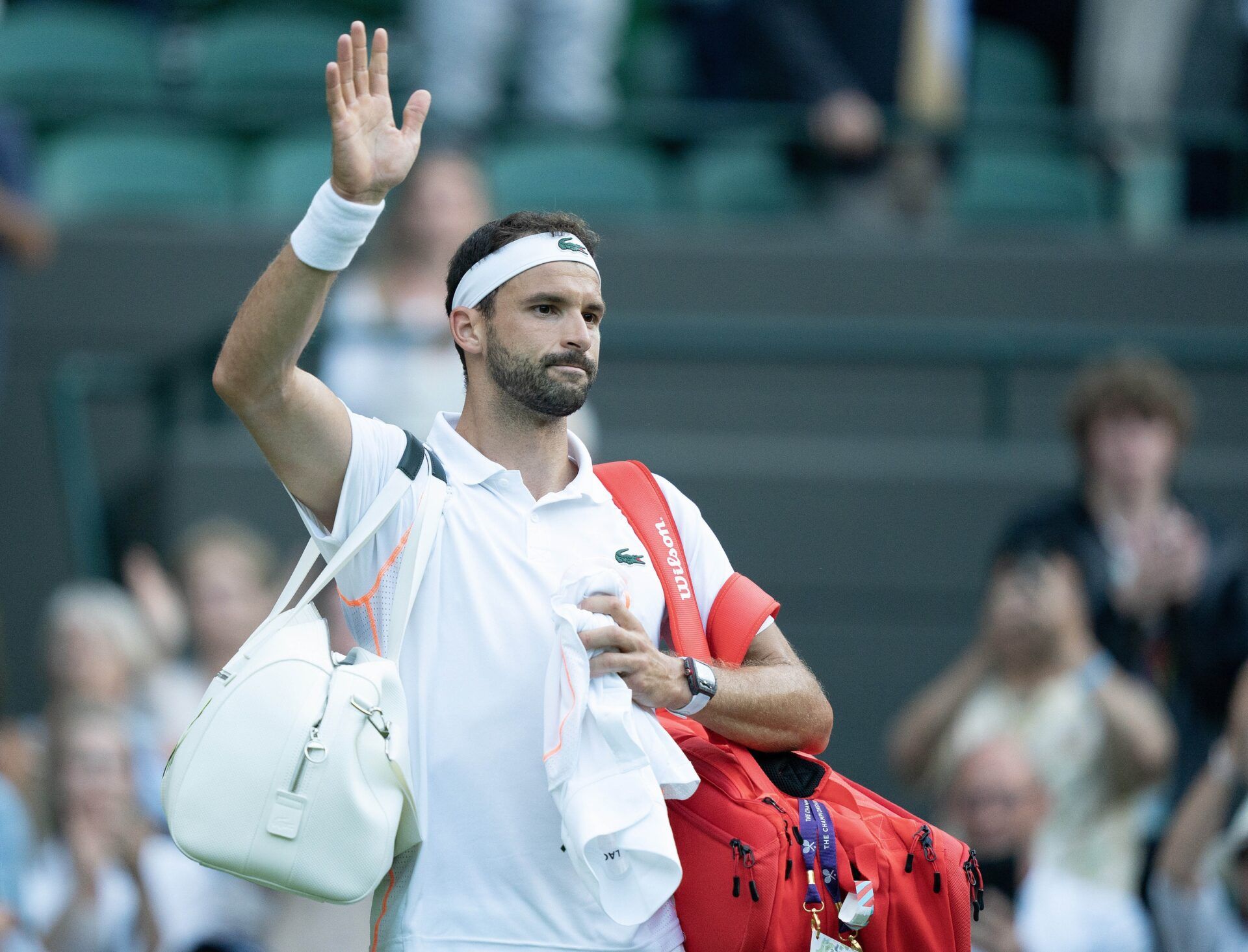 Grigor Dimitrov (BUL) waves as he leaves the court after a match against Holger Rune (DEN) on day eight at the All England Lawn Tennis and Croquet Club.