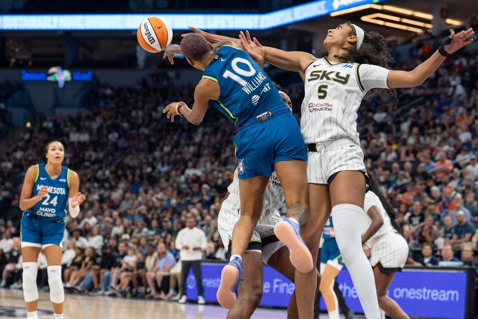Minnesota Lynx guard Courtney Williams (10) passes to Minnesota Lynx forward Napheesa Collier (24) as Chicago Sky forward Angel Reese (5) defends in the fourth quarter at Target Center.