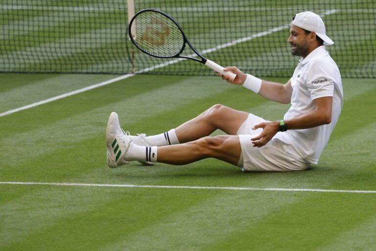 Grigor Dimitrov (BUL) stretches his foot after a fall against Jannik Sinner (ITA)(not pictured) on day eight of The Championships Wimbledon 2025 at All England Lawn Tennis and Croquet Club.