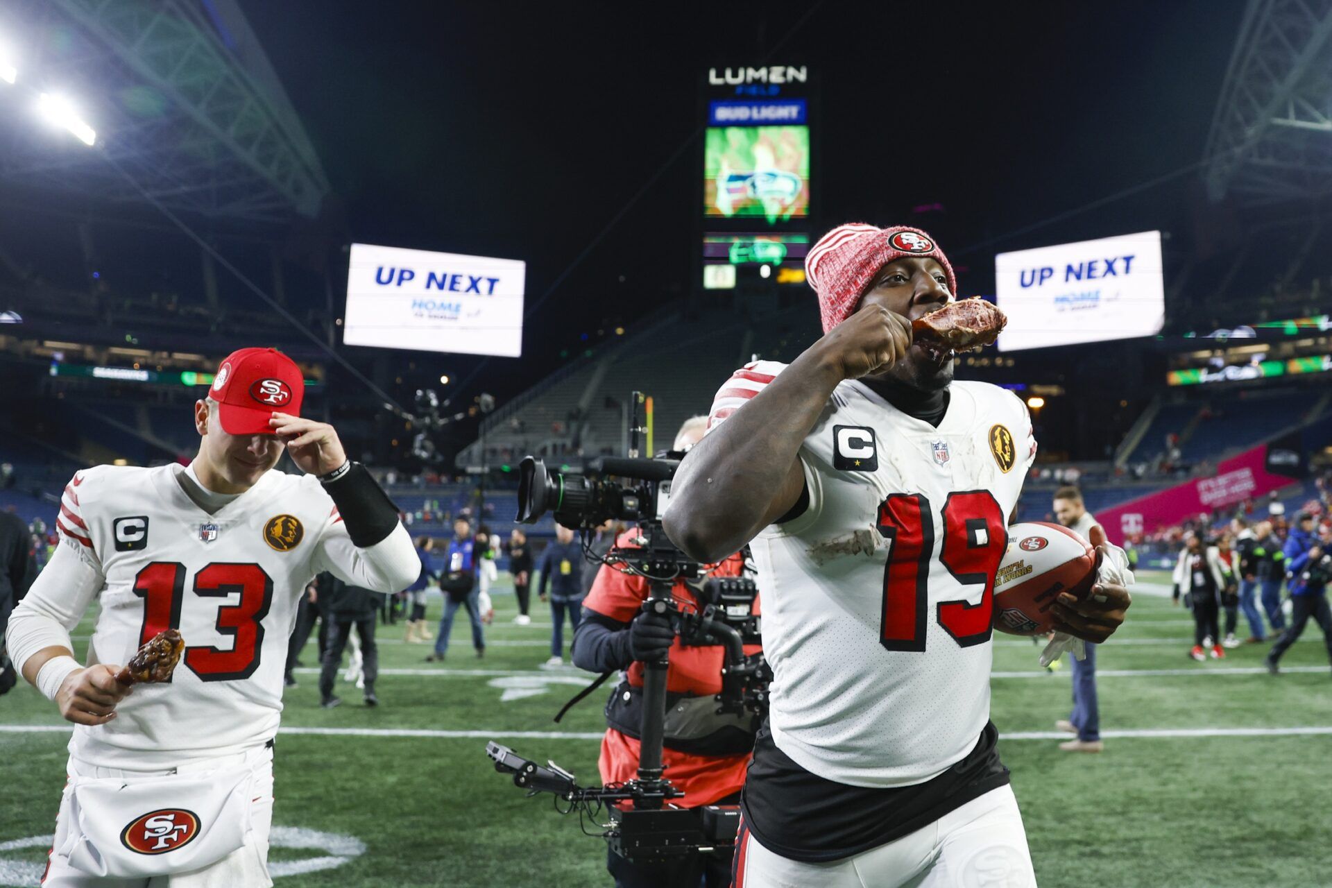 San Francisco 49ers wide receiver Deebo Samuel (19) eats a turkey leg as he and quarterback Brock Purdy (13) jog to the locker room following a 31-13 victory against the Seattle Seahawks at Lumen Field.