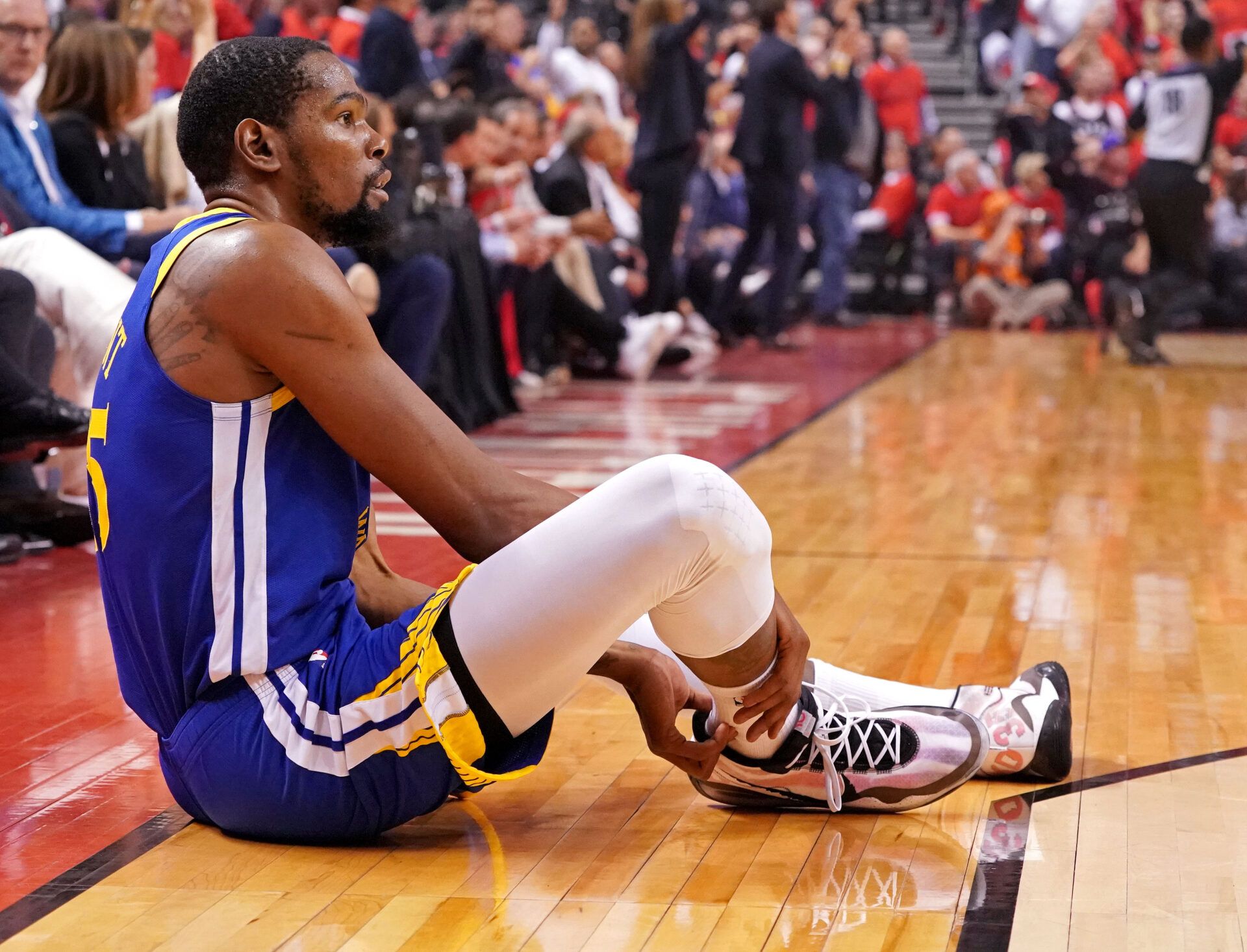 Golden State Warriors forward Kevin Durant (35) sits on the court after an apparent injury during the second quarter in game five against the Toronto Raptors of the 2019 NBA Finals at Scotiabank Arena.