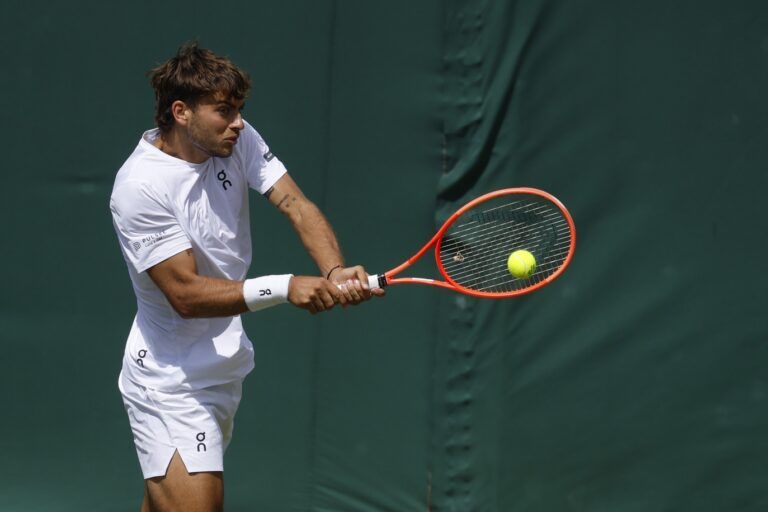 Flavio Cobolli (ITA) hits a backhand against Marin Cilic (CRO)(not pictured) on day eight of The Championships Wimbledon 2025 at All England Lawn Tennis and Croquet Club.