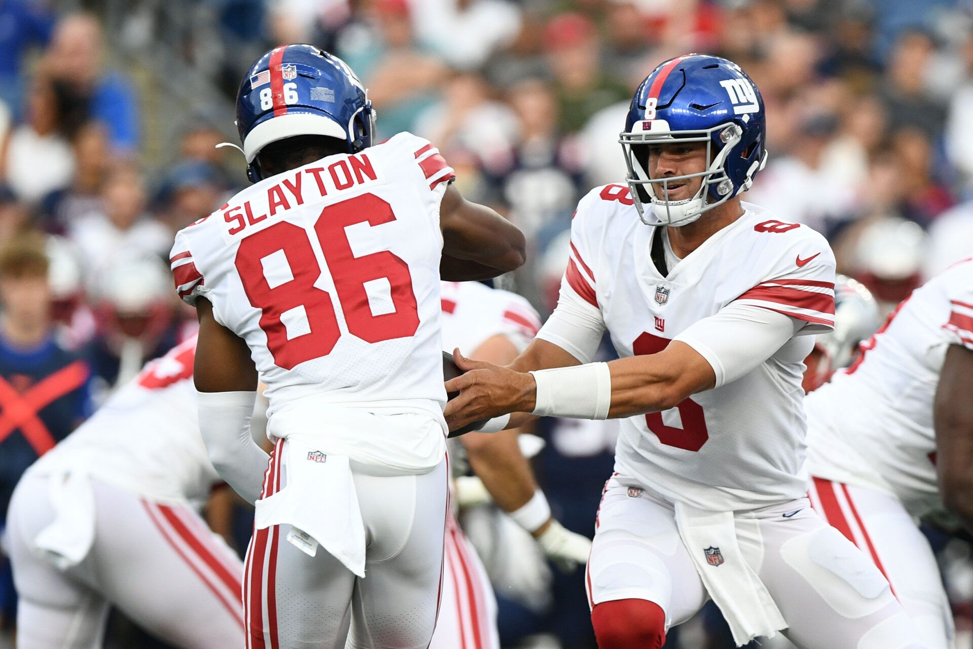 New York Giants quarterback Daniel Jones (8) hands the ball off to wide receiver Darius Slayton (86) during the first half of a game against the New England Patriots at Gillette Stadium.