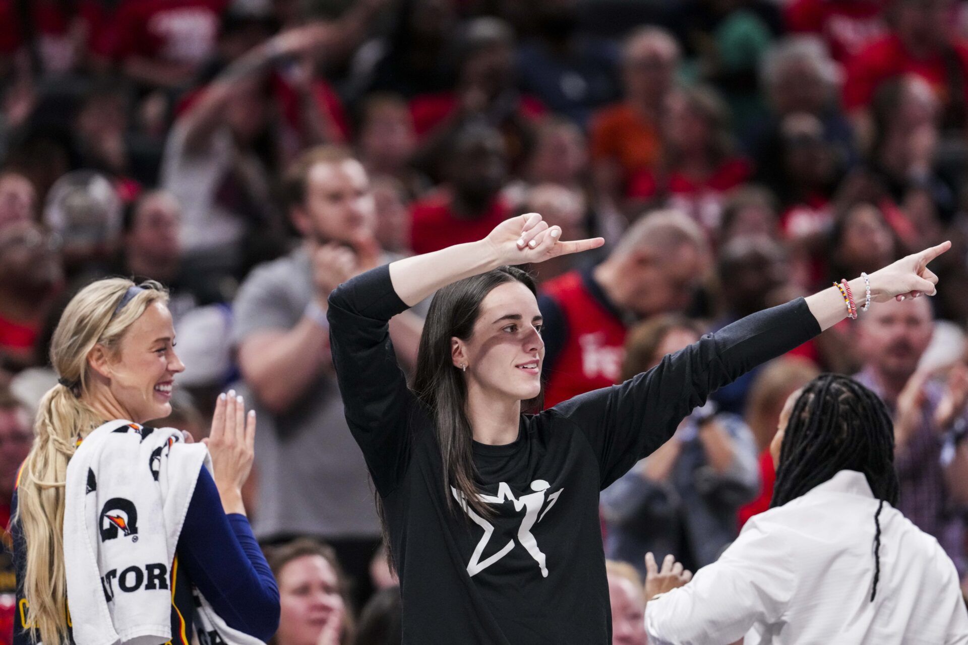 Indiana Fever guards Sophie Cunningham and Caitlin Clark celebrate from the bench during a game against the Las Vegas Aces at Gainbridge Fieldhouse.