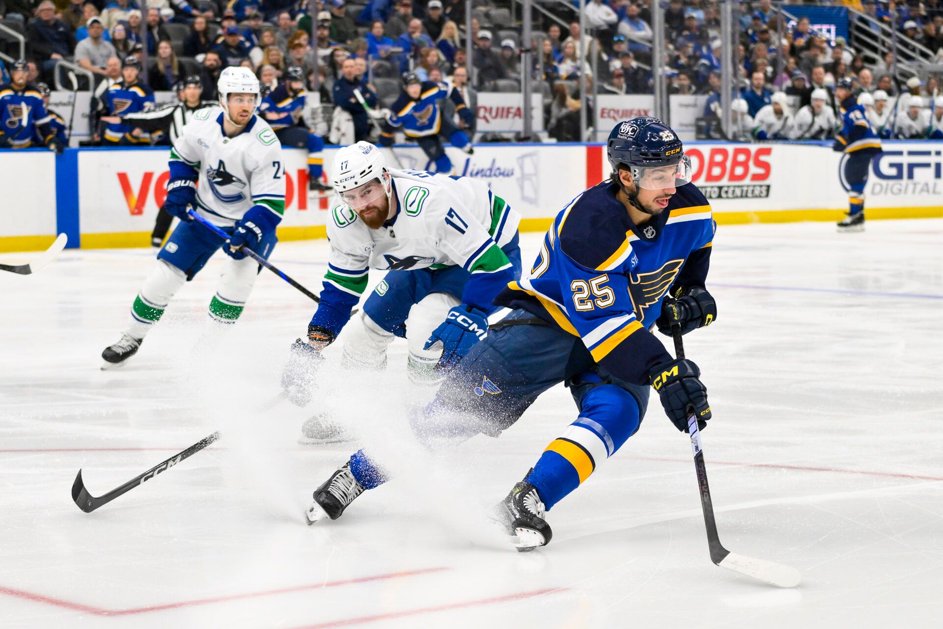 St. Louis Blues center Jordan Kyrou (25) controls the puck as Vancouver Canucks defenseman Filip Hronek (17) defends during the second period at Enterprise Center.
