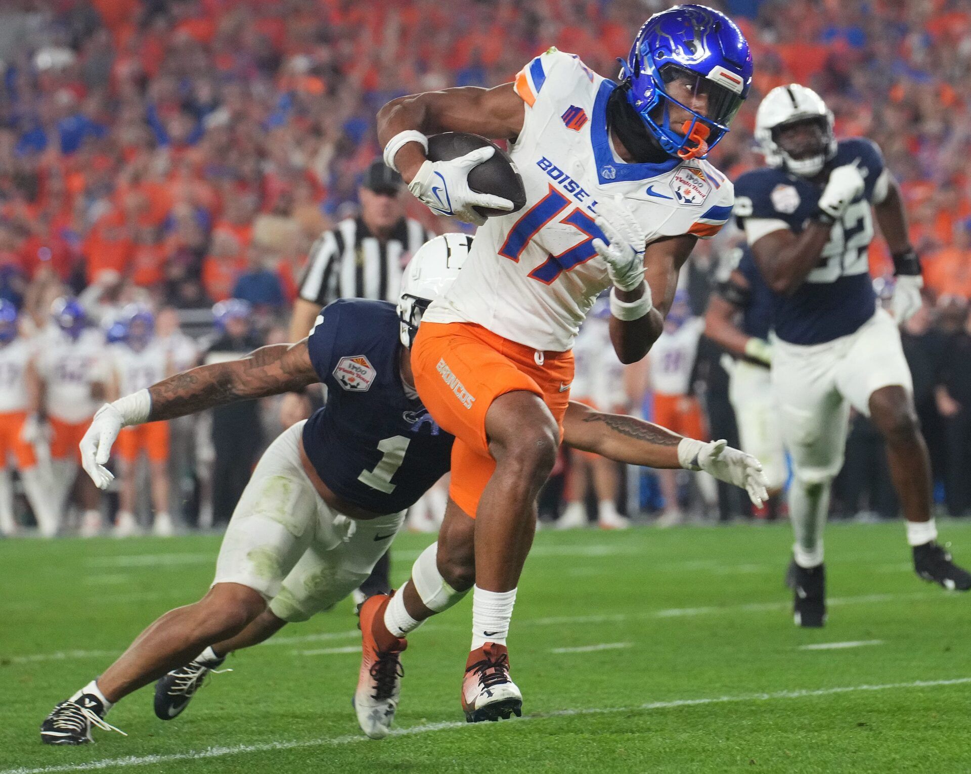 Boise State Broncos receiver Prince Strachan (17) tries to break away from Penn State Nittany Lions safety Jaylen Reed (1) during their Vrbo Fiesta Bowl matchup at State Farm Stadium.
