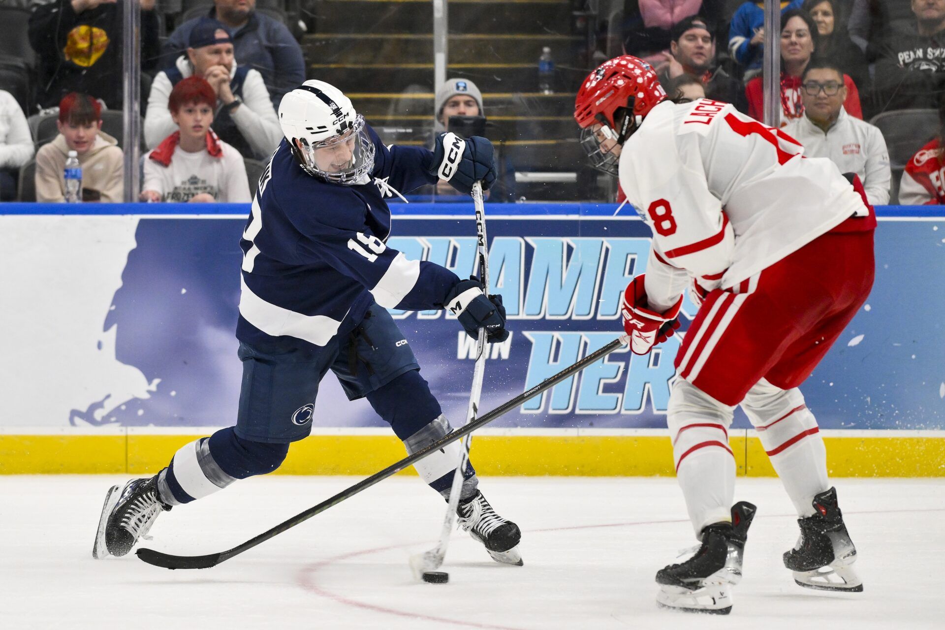 Penn State Nittany Lions forward Aiden Fink (18) shoots as Boston University Terriers forward Shane Lachance (18) defends during the third period of the Frozen Four college ice hockey national semifinals at Enterprise Center.