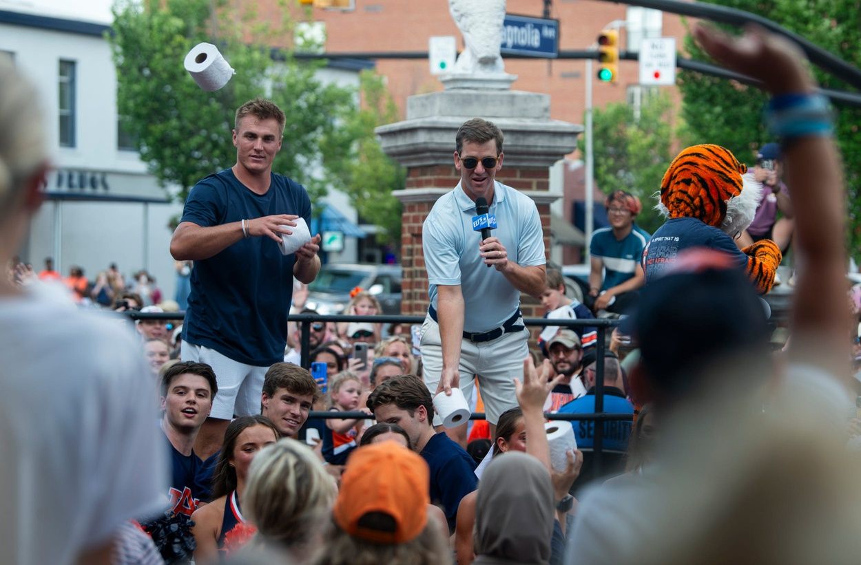 Former Auburn quarterback Bo Nix and retired NFL quarterback Eli Manning toss toilet paper to fans during the filming of the ESPN show Eli’s Places at Toomer’s Corner in Auburn, Ala. on Tuesday, July 8, 2025.