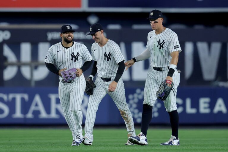 New York Yankees left fielder Jasson Dominguez (24) and center fielder Cody Bellinger (35) and right fielder Aaron Judge (99) celebrate after defeating the Seattle Mariners at Yankee Stadium.