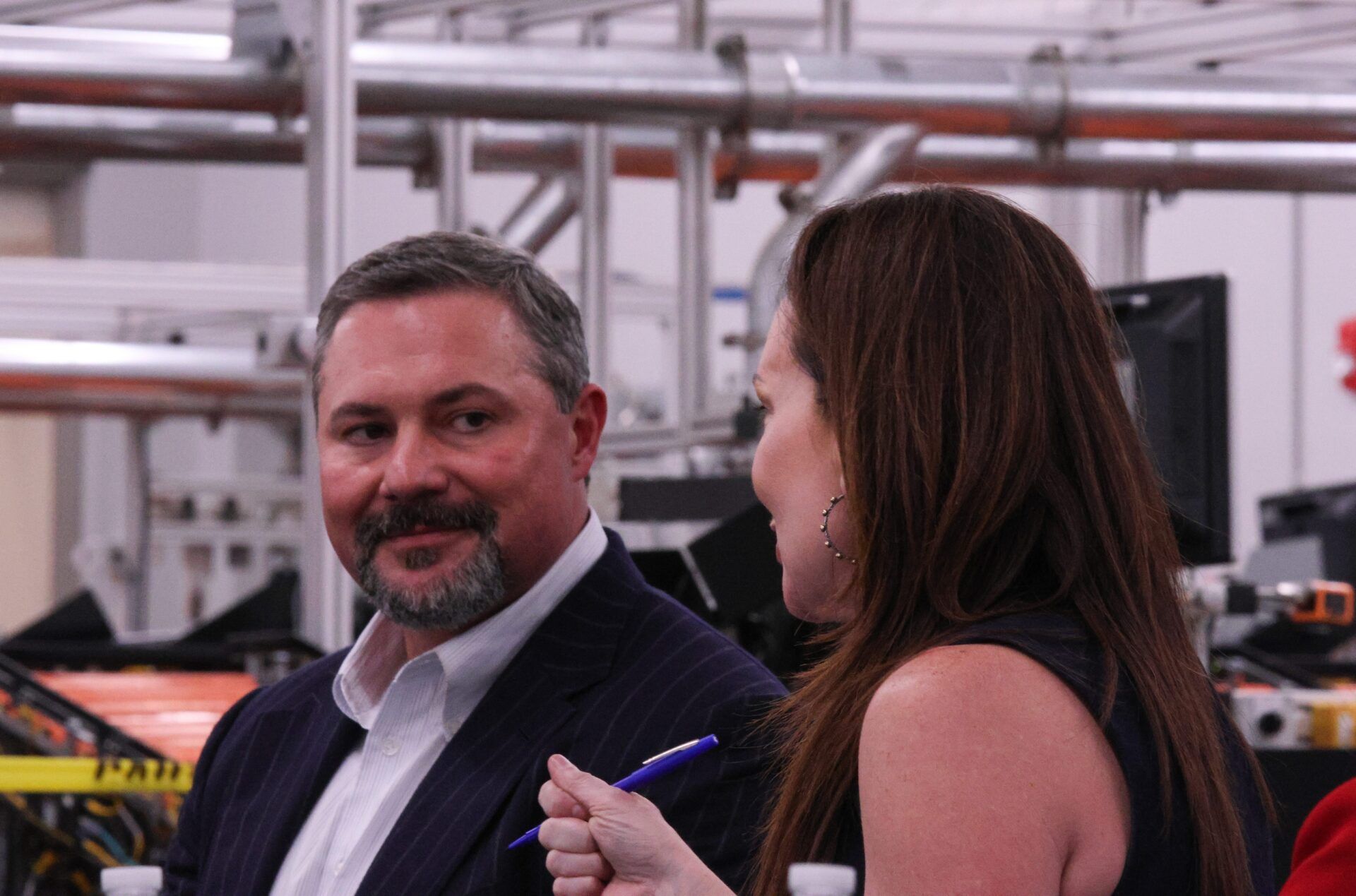 Texas Tech University System Board of Regents Chairman Cody Campbell listens to U.S. Department of Agriculture Secretary Brooke Rollins speak to other Texas Tech leaders at the USDA Agricultural Marketing Service Cotton Classification Complex on April 16, 2025