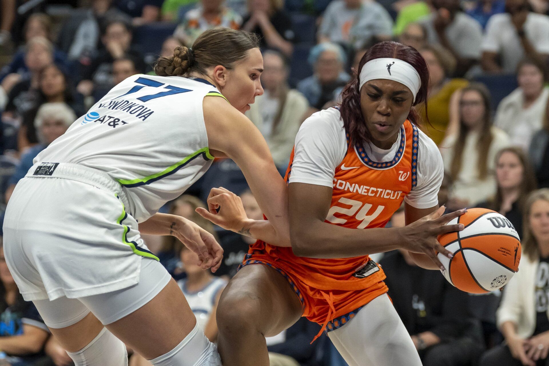 Connecticut Sun forward Aneesah Morrow (24) dribbles the ball as Minnesota Lynx forward Maria Kliundikova (77) plays defense in the second half at Target Center.