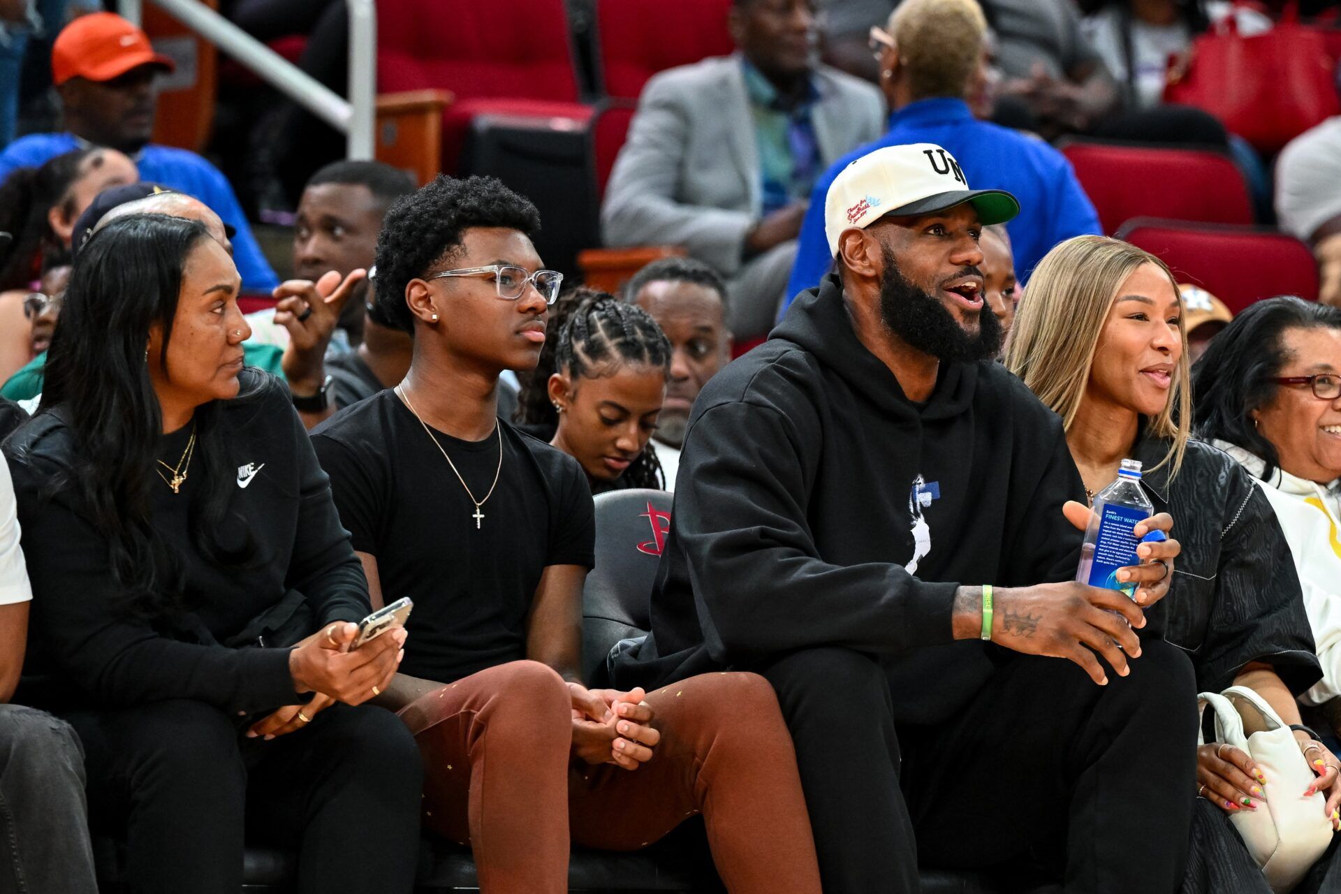 Los Angeles Lakers forward LeBron James sits with his wife Savannah James (right), son Bryce Maximus James (left) and his mother Gloria Marie James (left) court side of the between the McDonald's All American East and the McDonald's All American West at Toyota Center.