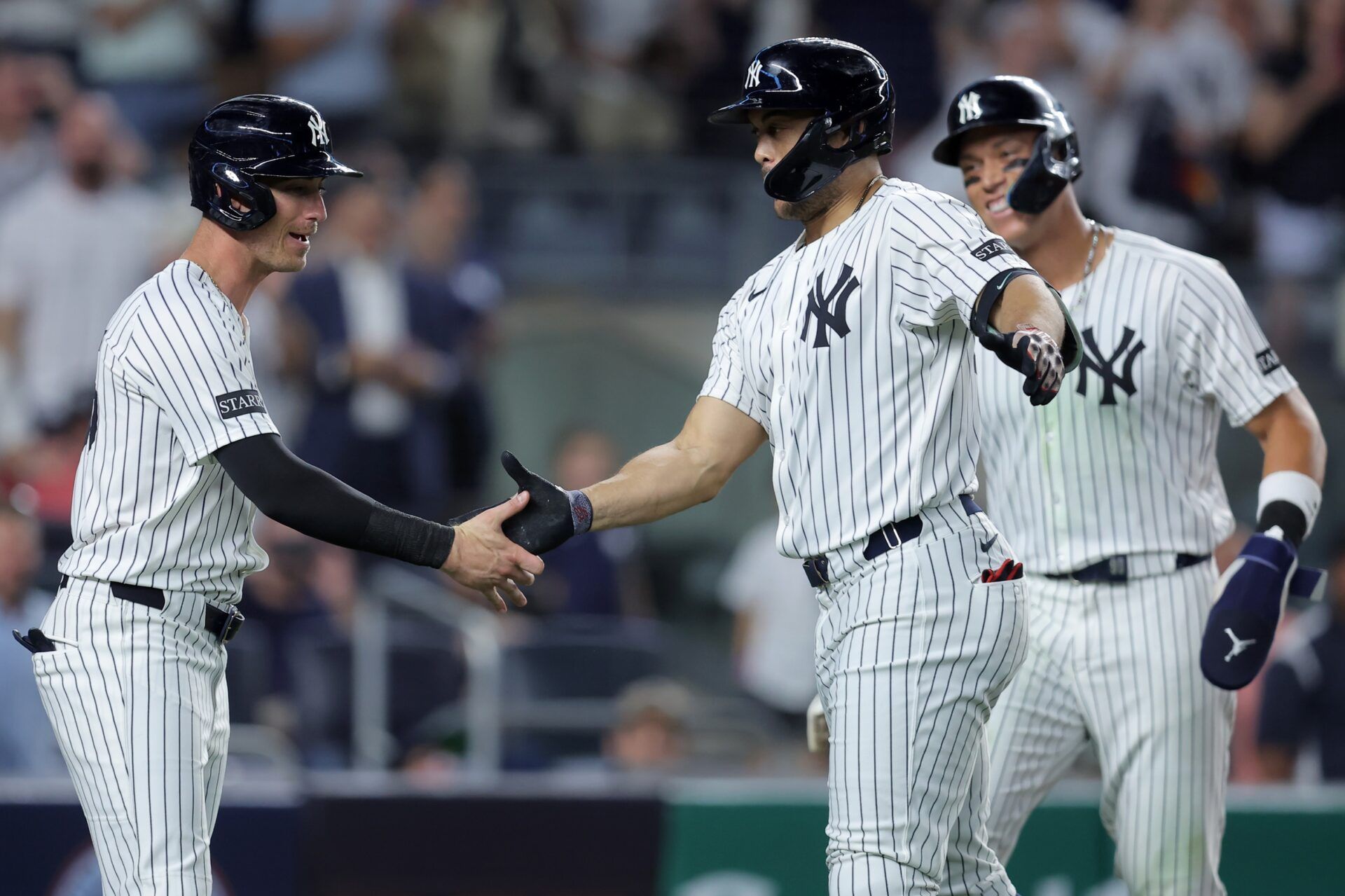 New York Yankees designated hitter Giancarlo Stanton (27) celebrates his three run home run against the Seattle Mariners with center fielder Cody Bellinger (35) and right fielder Aaron Judge (99) during the sixth inning at Yankee Stadium.