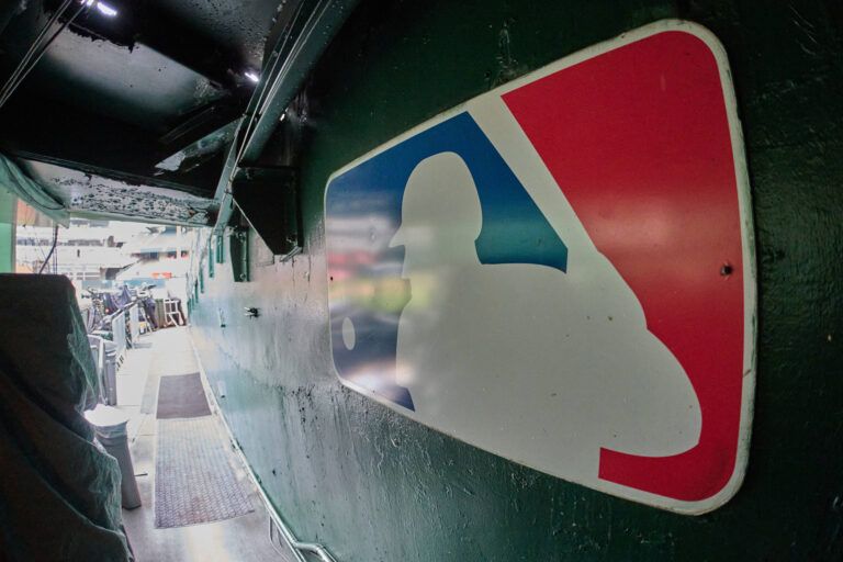 The major league baseball logo is seen on signage near the player's entrance to the field at Oakland-Alameda County Coliseum before the game between the Oakland Athletics and the Milwaukee Brewers.