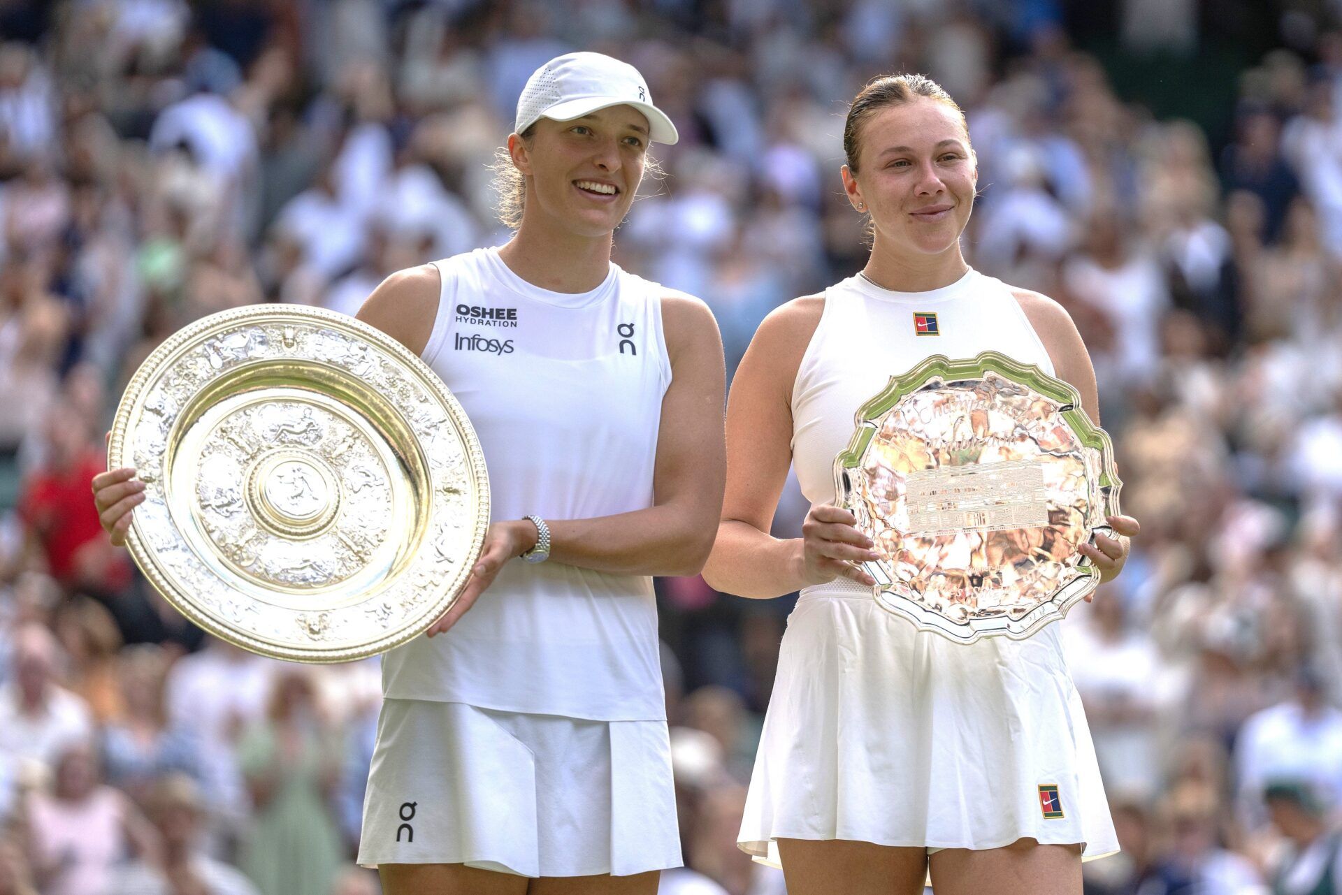 Iga Swiatek of Poland and  Amanda Anisimova of the United States pose with their trophies after the women’s singles final on day 13 at All England Lawn Tennis and Croquet Club.