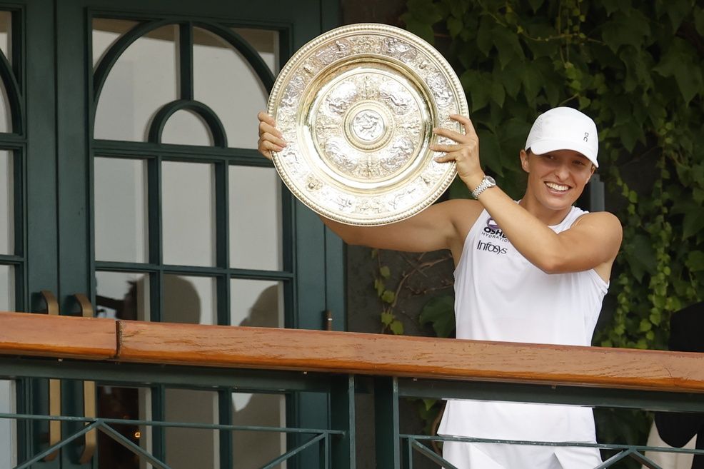 Iga Swiatek (POL) stands on the South West Hall balcony holding the Venus Rosewater Dish after her match against Amanda Anisimova (USA)(not pictured) in the ladies' singles championship on day thirteen of The Championships Wimbledon 2025 at All England Lawn Tennis and Croquet Club.
