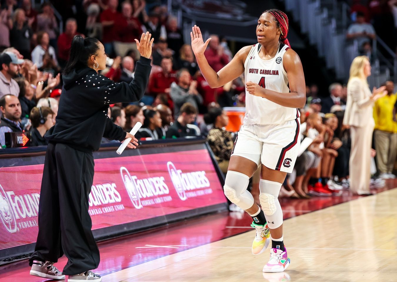 South Carolina Gamecocks forward Aliyah Boston (4) high fives head coach Dawn Staley as she leaves the game against the Georgia Lady Bulldogs in the second half at Colonial Life Arena.