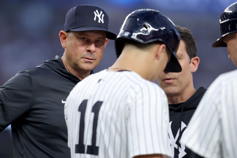 New York Yankees manager Aaron Boone (17) checks on shortstop Anthony Volpe (11) after Volpe was hit by a pitch during the second inning against the Boston Red Sox at Yankee Stadium.