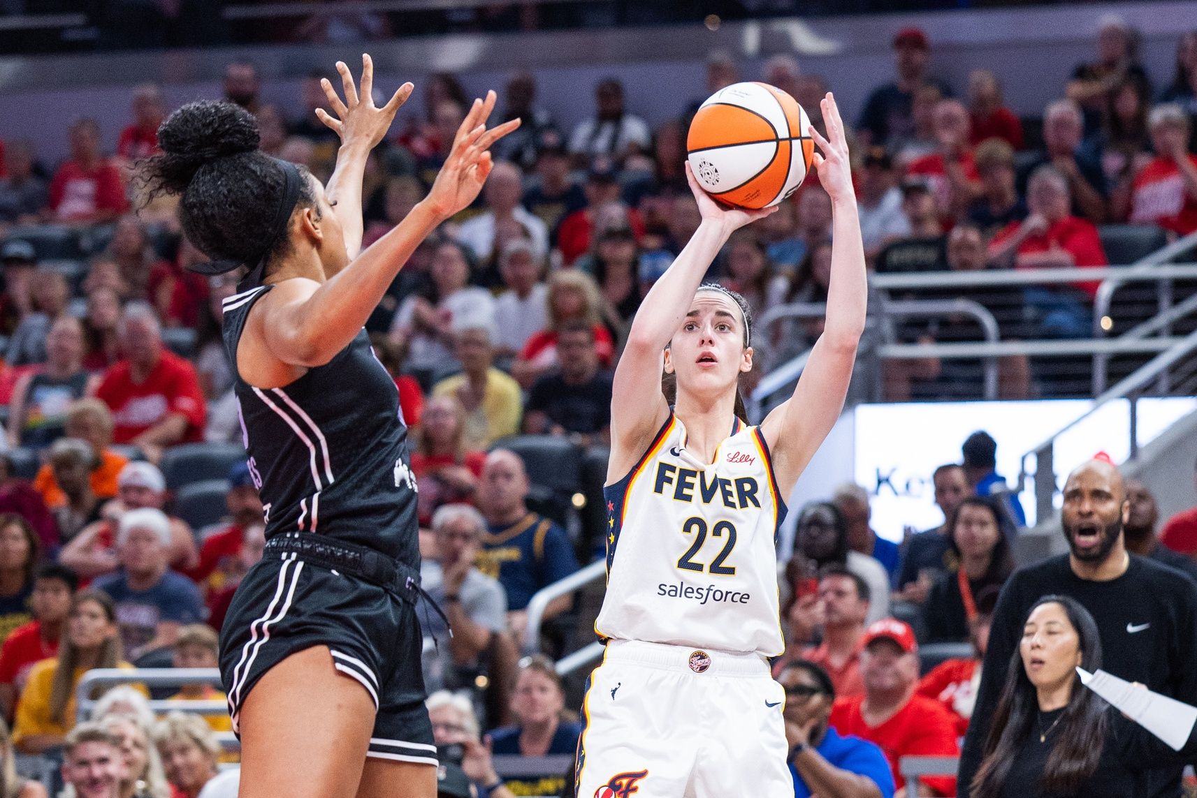 Indiana Fever guard Caitlin Clark (22) shoots the ball while Golden State Valkyries forward Monique Billings (25) defends in the first half at Gainbridge Fieldhouse.