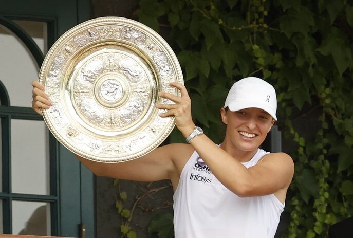 Iga Swiatek (POL) stands on the South West Hall balcony holding the Venus Rosewater Dish after her match against Amanda Anisimova (USA)(not pictured) in the ladies' singles championship on day thirteen of The Championships Wimbledon 2025 at All England Lawn Tennis and Croquet Club.