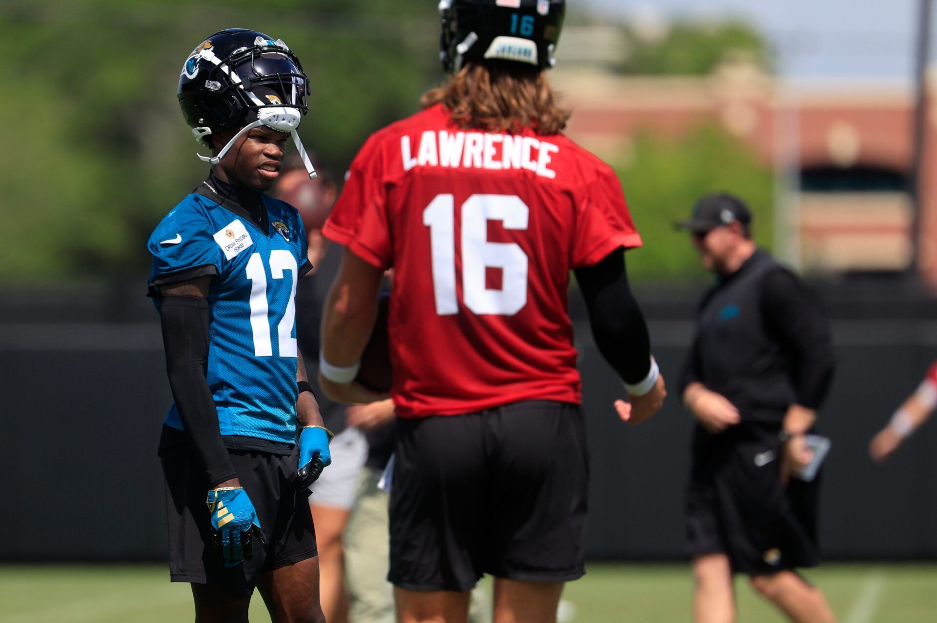 Jacksonville Jaguars wide receiver Travis Hunter (12) talks with quarterback Trevor Lawrence (16) during the 10th organized team activity at Miller Electric Center Wednesday, June 4, 2025 in Jacksonville, Fla. [Corey Perrine/Florida Times-Union]