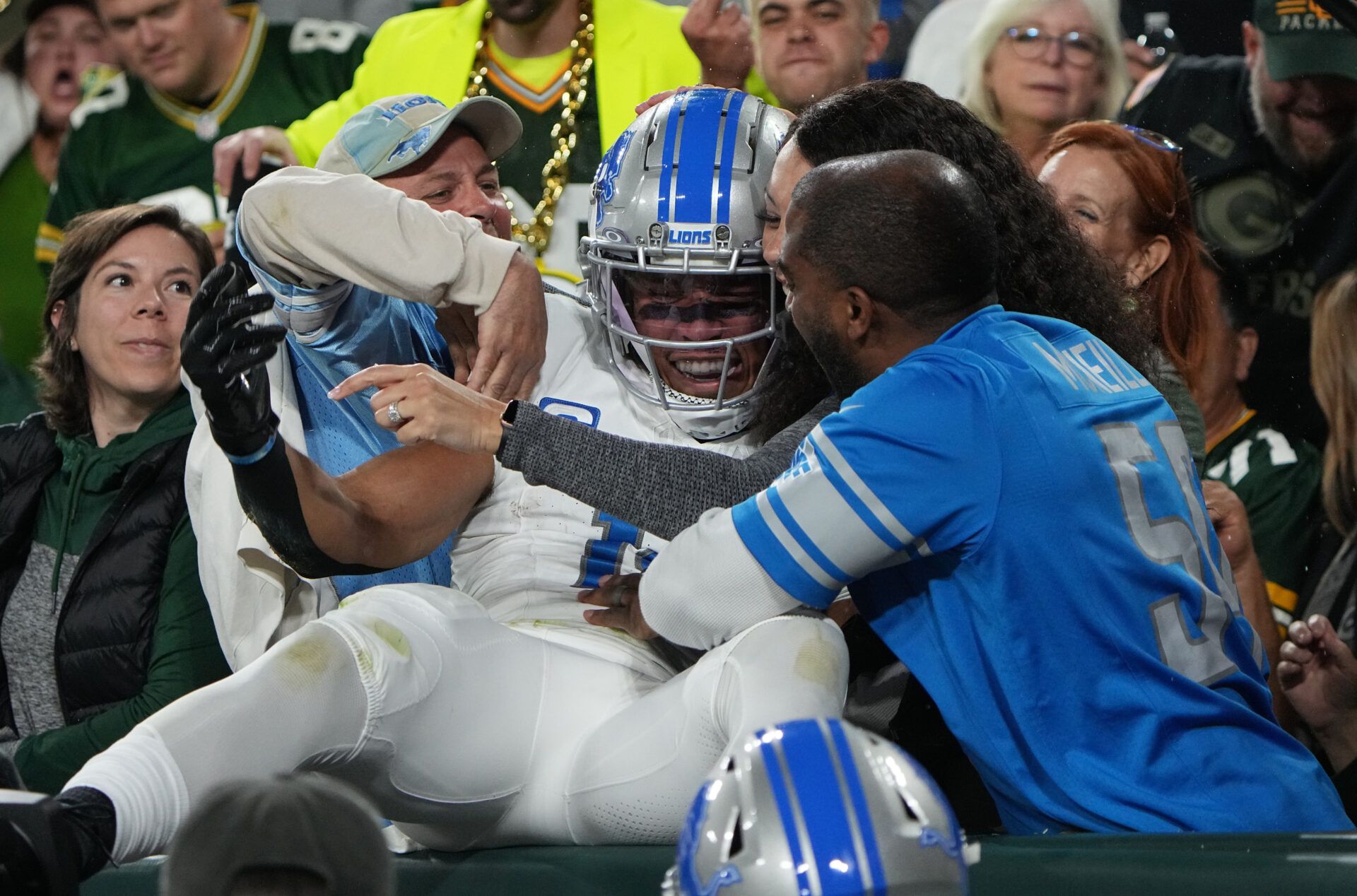 Detroit Lions wide receiver Amon-Ra St. Brown (14) celebrates his touchdown reception with fans during the first quarter against the Green Bay Packers at Lambeau Field.