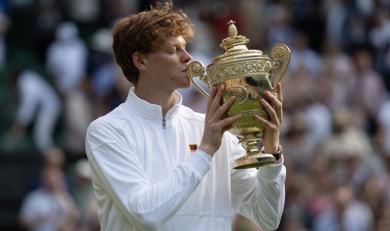 Jannik Sinner of Italy kisses the trophy after winning the menÕs singles final match against Carlos Alcaraz of Spain on day 14 at All England Lawn Tennis and Croquet Club.