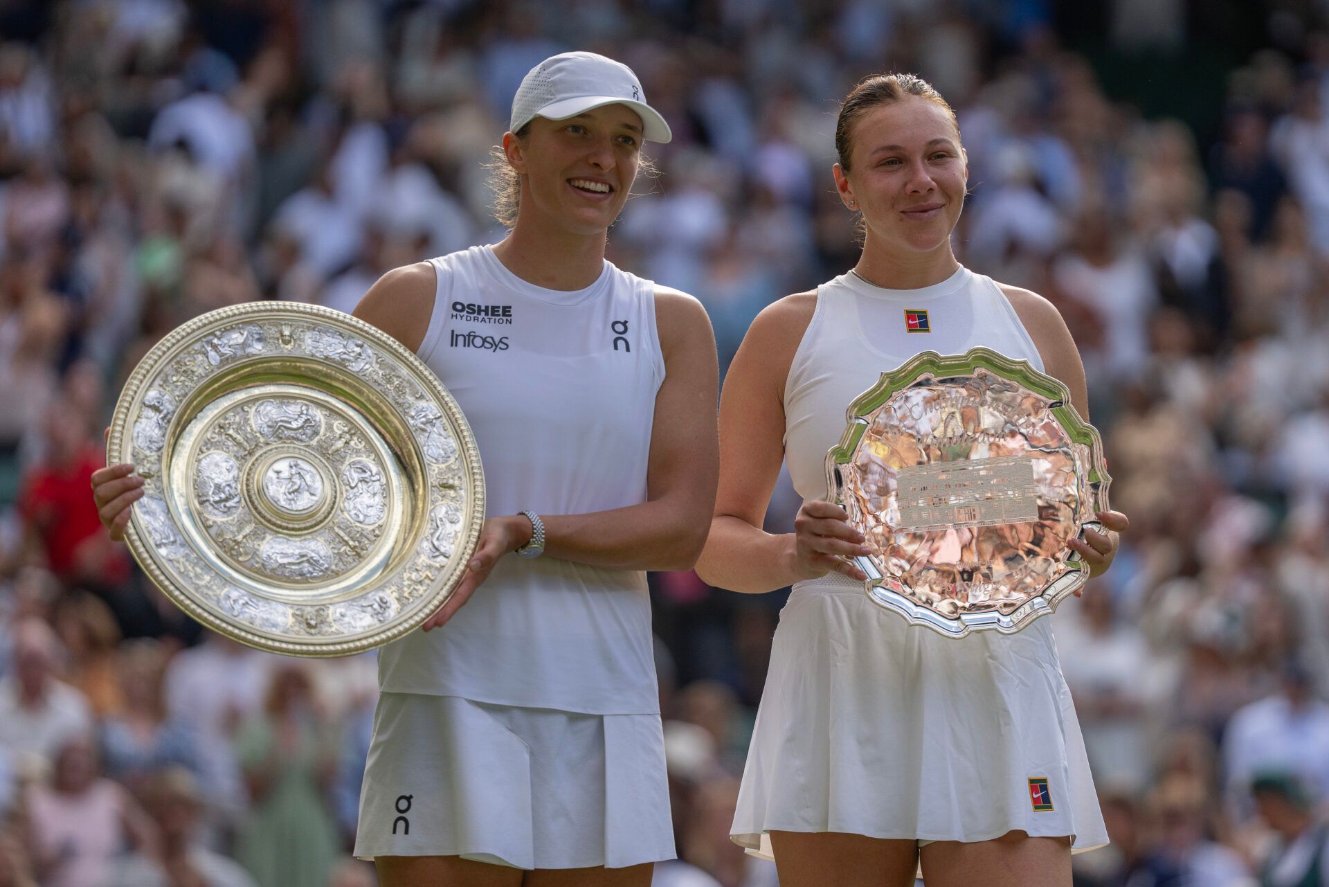 Iga Swiatek of Poland and  Amanda Anisimova of the United States pose with their trophies after the women’s singles final on day 13 at All England Lawn Tennis and Croquet Club.